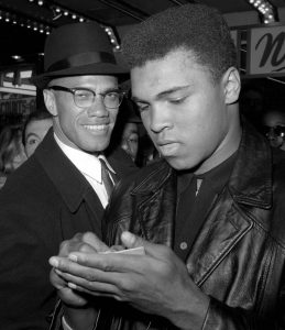 In this March 1, 1964, photo, heavyweight boxing champion Muhammad Ali, right, is shown with black muslim leader Malcolm X outside the Trans-Lux Newsreel Theater in New York, after viewing the screening of a film about Ali's title fight with Sonny Liston. Ali turns 70 on Jan. 17, 2012.  (AP Photo)