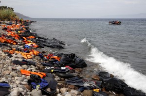 Syrian refugees arrive on a beach covered with life vests and deflated dinghies on the Greek island of Lesbos in an overcrowded dinghy after crossing a part of the Aegean Sea from the Turkish coast September 22, 2015. REUTERS/Yannis Behrakis - RTX1RUYU